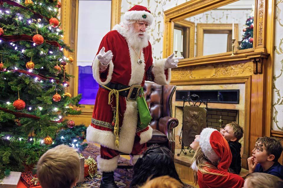 Santa speaks to a group of children near a Christmas Tree at Christmas on the Quad. Photo by Sarah Conroy.