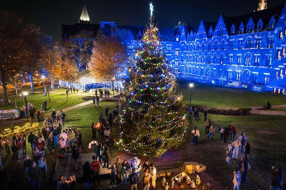 Christmas on the Quad attendees gather around a large Christmas tree on the quad. Photo by Sarah Conroy.