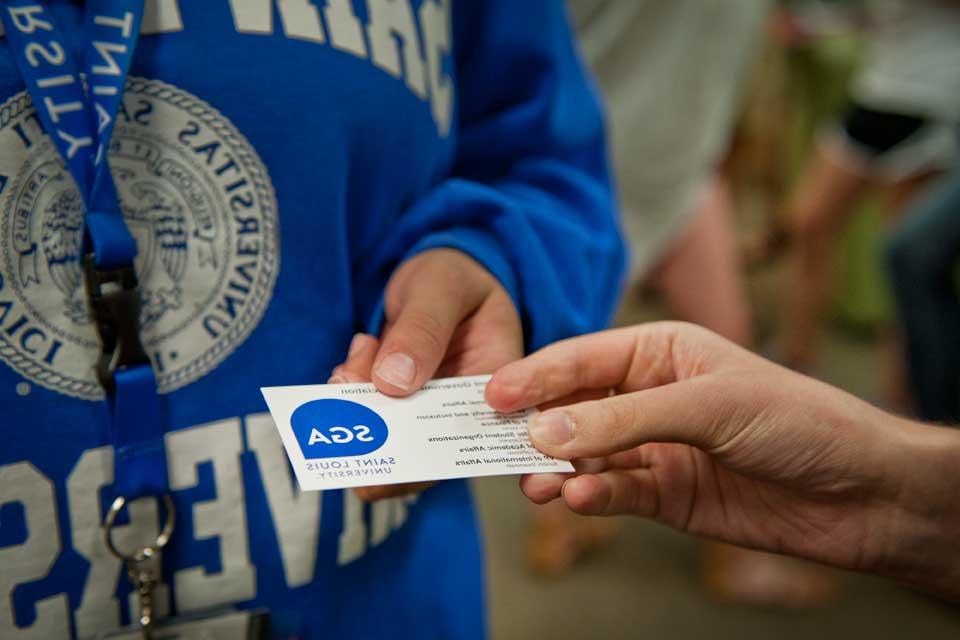 Student holding a SGA business card