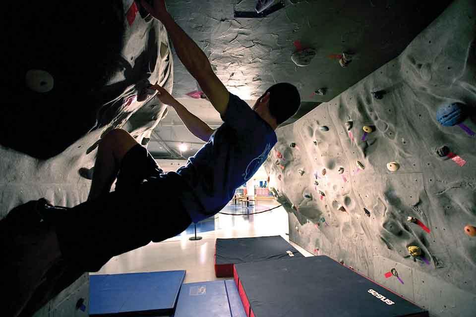 Student in profile using a climbing wall